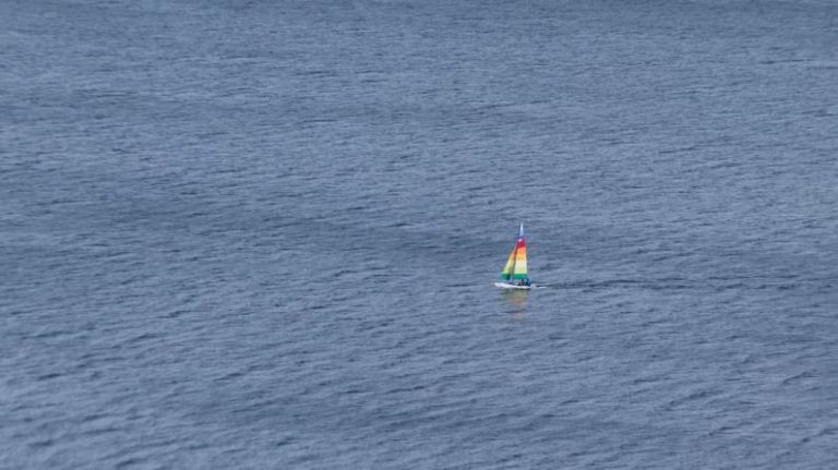 Solo Sailor - wind surf boat on the body of water