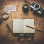 Compass Adventure - flat ray photography of book, pencil, camera, and with lens