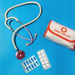 First Aid Kit - a bag of pills, a stethoscope, and a first aid kit