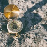 Navigational Compass - gold-colored compass on stone
