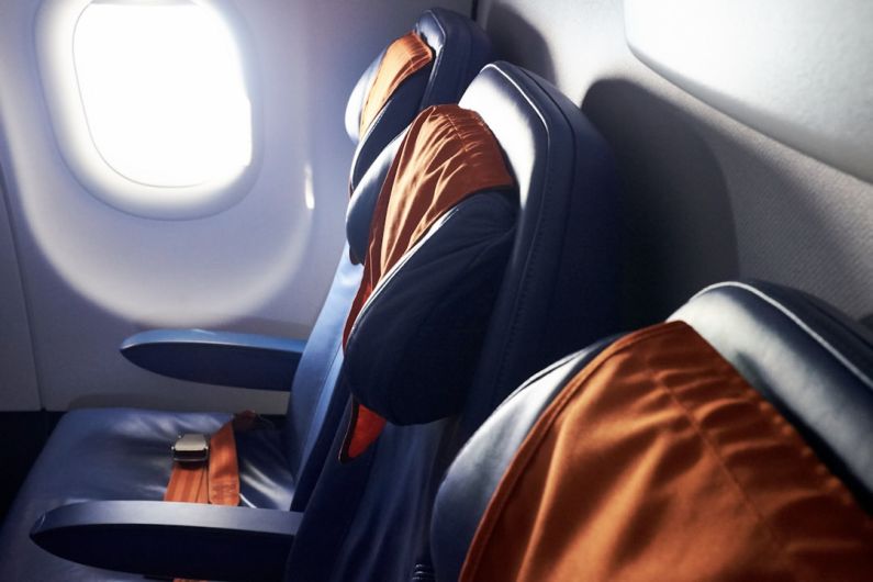 Polite Passenger - black leather airplane seat beside window