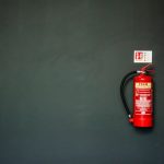Fire Extinguisher - red fire extinguisher on gray wall