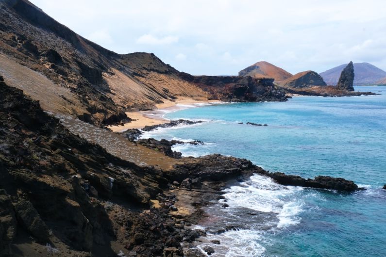 Galapagos Islands - brown and green mountains beside body of water during daytime